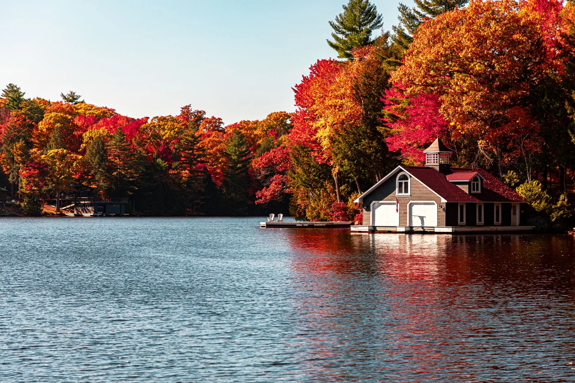 Lakeside cottage surrounded by vibrant fall foliage in Ontario, Canada