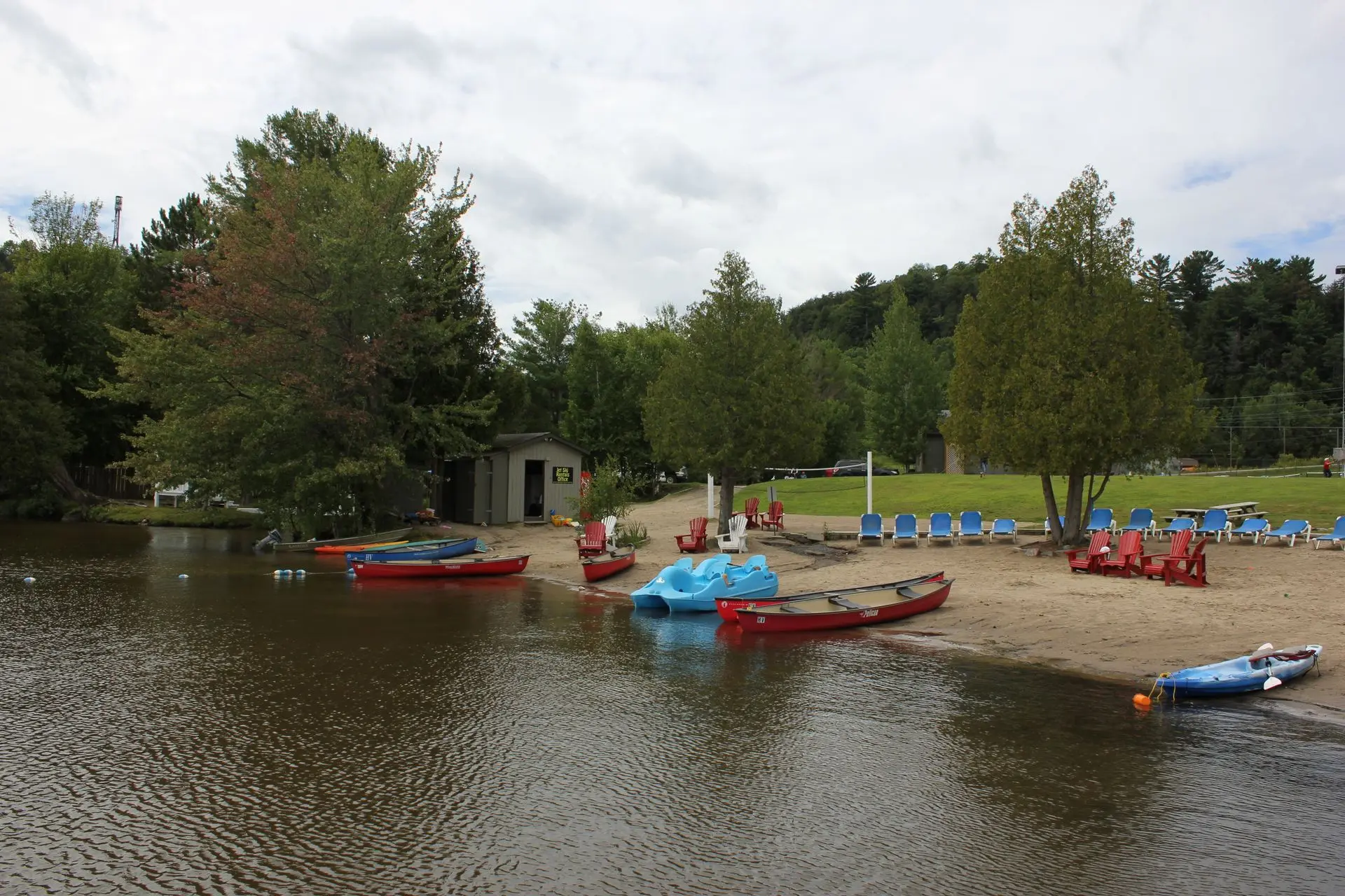 Lakeside beach with canoes and trees in Huntsville, Ontario